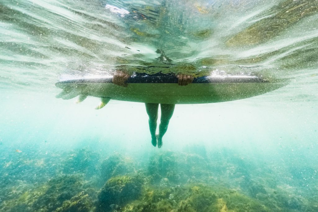 Underwater drone shot of surfer on his surfboard